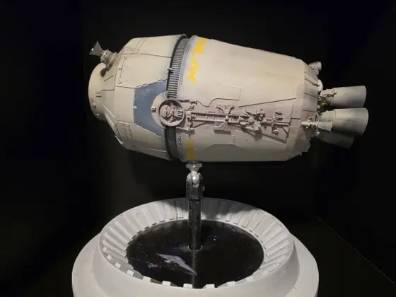 Studio-scale escape pod model on a display stand, side view
