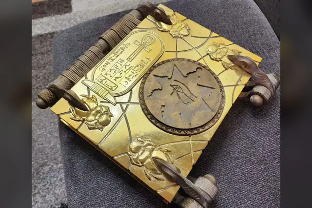 Replica Book of the Living with a gold cover, scarabs and cartouche