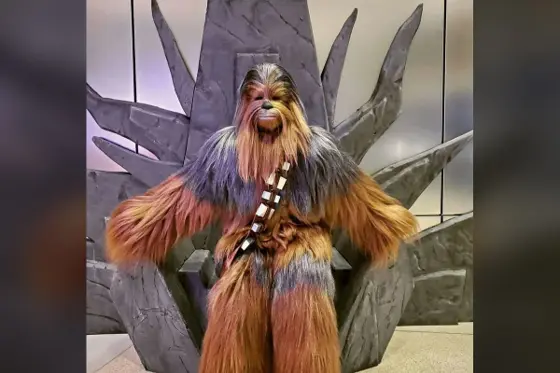 Foam-sculpted throne with a costumed visitor posing in front