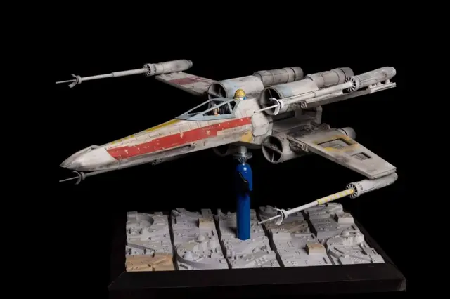 Studio-scale X-wing model Red 7 on a display base, front three-quarter view